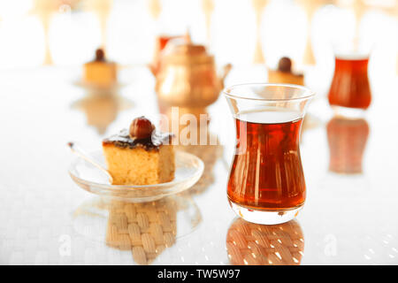 Türkischer Tee im traditionellen Glas mit Dessert auf den Tisch Stockfoto