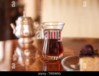 Türkischer Tee im traditionellen Glas auf dem Tisch Stockfoto