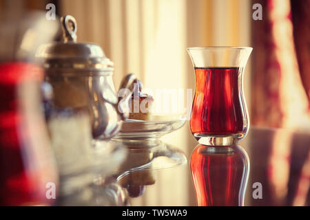 Türkischer Tee im traditionellen Glas auf dem Tisch Stockfoto
