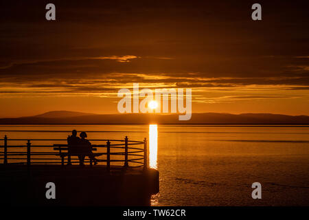 Trafalgar Piont, Morecambe, Lancashire, Großbritannien, 18. Juni 2019 Besucher sehen die Sonne vom Ende der Steinernen Steg bekannt wie Trafalgar Piont gehen. Credit: Fotografieren Nord/Alamy leben Nachrichten Stockfoto