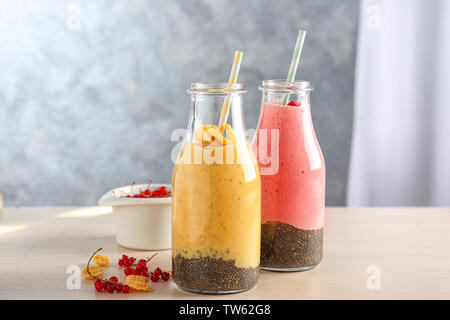 Bunte Smoothies mit Chia Samen in Flaschen auf dem Tisch Stockfoto