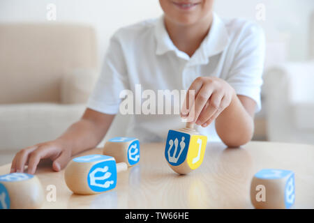 Jüdische Junge spielt mit Dreidel zu Hause Stockfoto