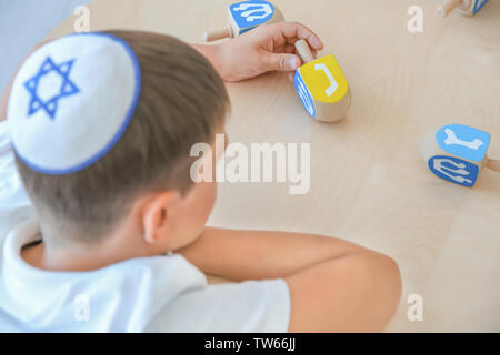 Jüdische Junge spielt mit Dreidel zu Hause Stockfoto