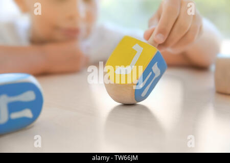 Jüdische Junge spielt mit Dreidel zu Hause Stockfoto