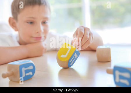 Jüdische Junge spielt mit Dreidel zu Hause Stockfoto