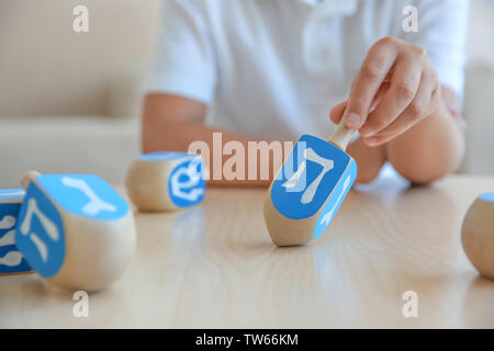 Jüdische Junge spielt mit Dreidel zu Hause Stockfoto