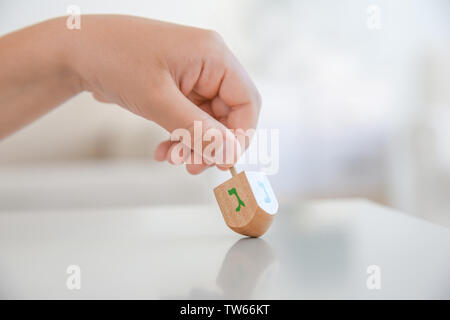 Jüdische Junge spielt mit Dreidel zu Hause Stockfoto