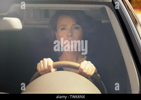 Emotionale junge Frau das Auto fahren, Blick von außen durch die Windschutzscheibe Stockfoto