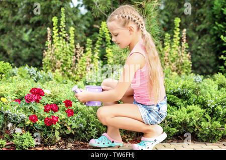 Süße kleine Mädchen Blumen gießen im Garten Stockfoto