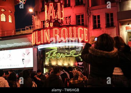 PARIS, Frankreich - 1. JANUAR 2008: Touristen fotografieren vor dem Moulin Rouge in der Nacht, einer der berühmtesten Pigalle Kabaretts und alle Läufer Stockfoto