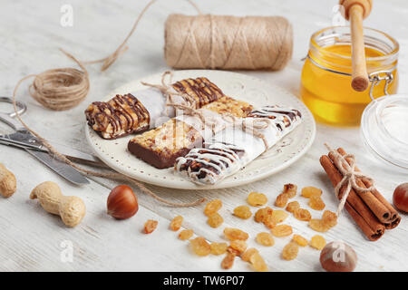 Mit Müsli Energy Bars und Zutaten auf hölzernen Tischplatte Stockfoto