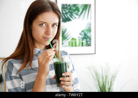 Frau trinkt spirulina Cocktail auf Innen Stockfoto