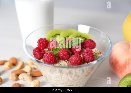 Schüssel Müsli mit Himbeeren und Kiwi auf Tisch Stockfoto