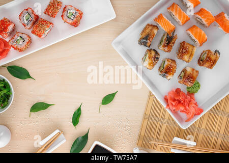 Zusammensetzung mit leckeren Sushi Rollen am Tisch Stockfoto