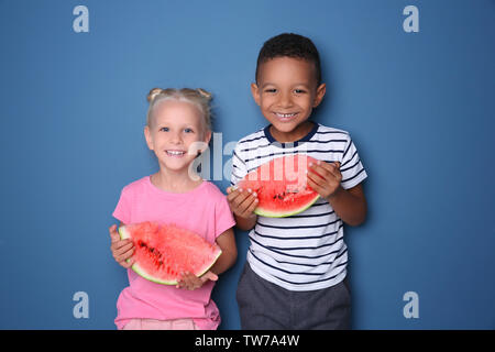 Cute Kids essen Wassermelone auf farbigen Hintergrund Stockfoto