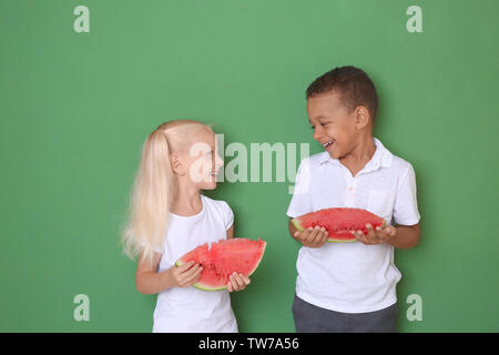 Cute Kids essen Wassermelone auf farbigen Hintergrund Stockfoto