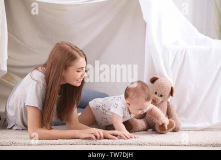 Junge Mutter und niedlichen Baby spielt im Zelt zu Hause Stockfoto