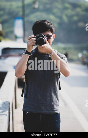 Unspezifische Mann mit einer Kamera in den Händen Spaziergänge rund um die Stadt und Fotografien der Stadt und der Bevölkerung für die Nachrichten. Stockfoto