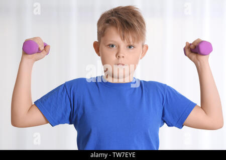 Übergewichtige Junge mit kurzhanteln Training zu Hause Stockfoto