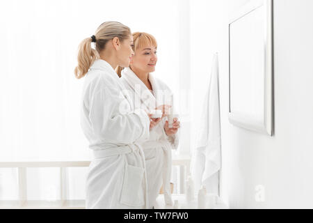 Reife Frau und ihre Verwendung von kosmetischen Produkten in Bad Tochter Stockfoto