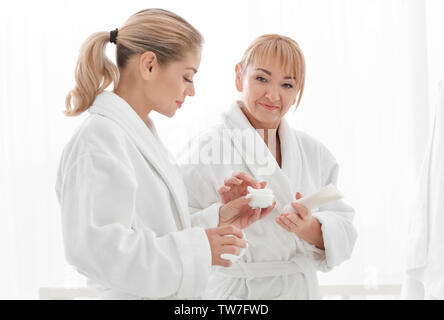 Reife Frau und ihre Verwendung von kosmetischen Produkten in Bad Tochter Stockfoto