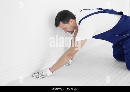 Arbeitnehmer heraus rollen Schaum Film auf dem Boden vor dem Teppich installation Stockfoto