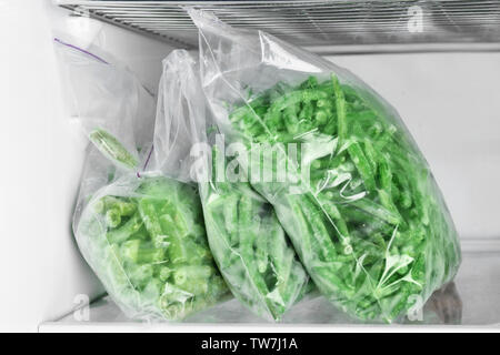 Plastiktaschen mit eingefrorenen grünen Bohnen im Kühlschrank Stockfoto