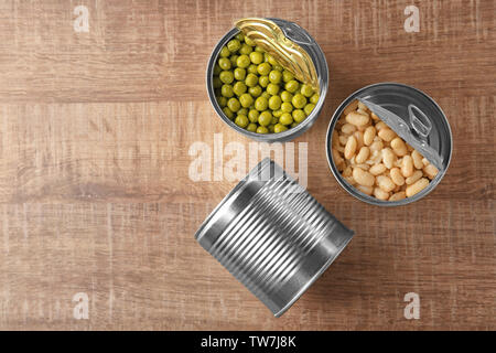 Blechdosen mit verschiedenen Speisen auf Holz- Hintergrund Stockfoto