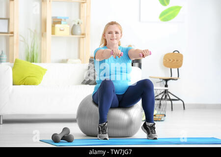 Übergewichtige Frau, die Übungen zu Hause Stockfoto
