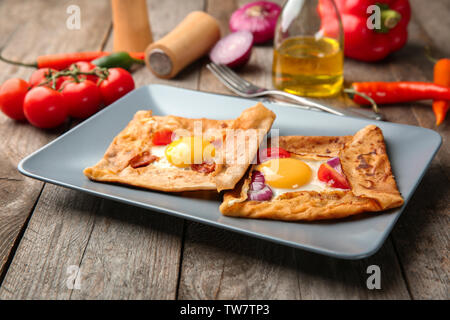 Leckere dünne Buchweizenpfannkuchen mit Eiern auf Platte Stockfoto