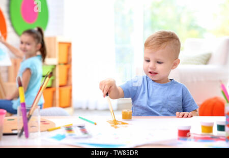 Little Boy und verschwommenes Mädchen Malerei im Innenbereich Stockfoto