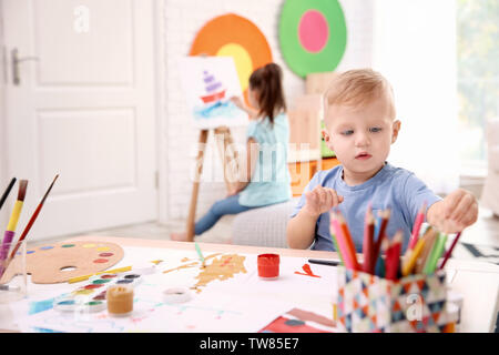 Little Boy und verschwommenes Mädchen Malerei im Innenbereich Stockfoto