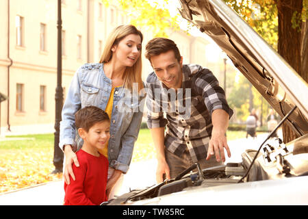 Junge Familie Reparatur Auto, draußen Stockfoto