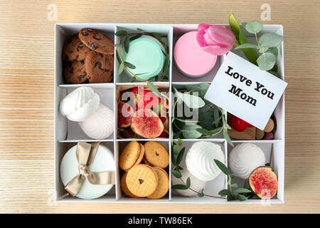 Hinweis mit den Worten "Liebe Mama" und viele andere Geschenke in Box auf hellen Hintergrund Stockfoto