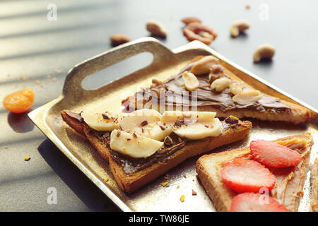 Leckere Toasts mit Schokoladencreme, Früchte und Nüsse auf Metall Fach Stockfoto