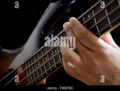 4 Strings vitange E-Bass Gitarre mit Händen spielen und anderen Perspektive Stockfoto