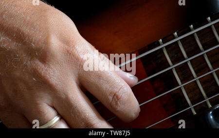 4 Strings vitange E-Bass Gitarre mit Händen spielen und anderen Perspektive Stockfoto