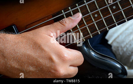 4 Strings vitange E-Bass Gitarre mit Händen spielen und anderen Perspektive Stockfoto