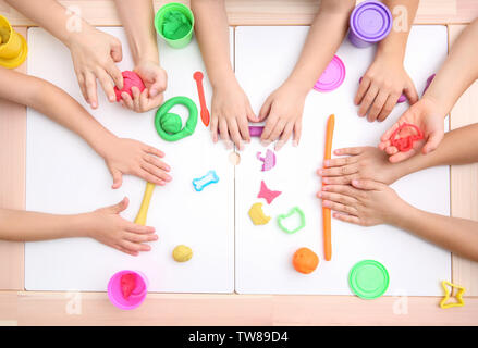 Kleine Kinder in Knetmasse Modelling am Schneidwerk zugeschaltet, Ansicht von oben Stockfoto