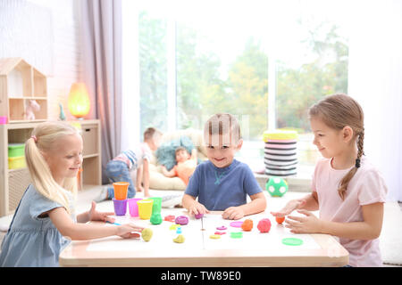 Kleine Kinder in Knetmasse Modellierung an der Kindertagesstätte eingerückt Stockfoto