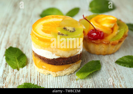 Leckere Kuchen mit Gelee Früchte auf Holz- Hintergrund Stockfoto