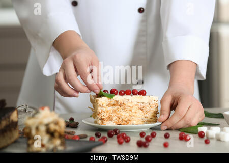 Koch dekorieren Stück leckeren Esterhazy Kuchen in der Küche Stockfoto