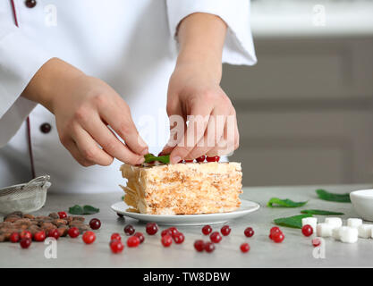 Koch dekorieren Stück leckeren Esterhazy Kuchen in der Küche Stockfoto