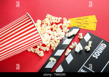 Zusammensetzung mit Popcorn, filmklappe und Kinotickets auf farbigen Hintergrund Stockfoto