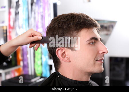 Professionelle Stylisten bürsten Haare des Kunden im Salon, Nahaufnahme Stockfoto