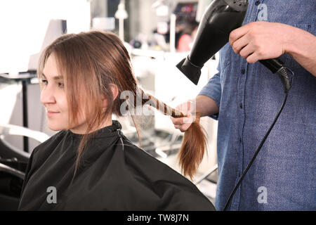 Professionelle Stylisten föhnen Woman's Haar, Salon, Nahaufnahme Stockfoto