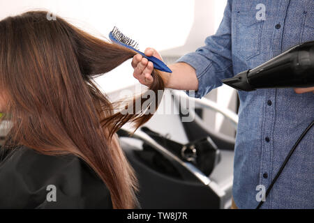 Professionelle Stylisten föhnen Woman's Haar, Salon, Nahaufnahme Stockfoto