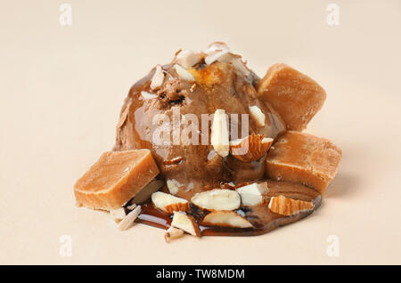 Schokolade Eis Ball mit Karamellsauce und Bonbons auf farbigen Hintergrund Stockfoto