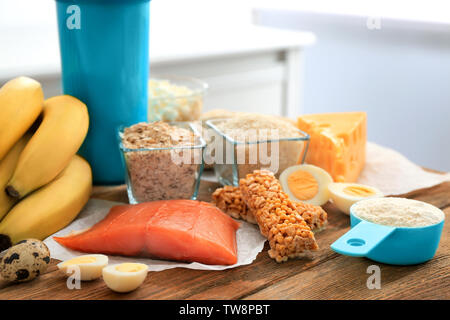 Schaufel mit Protein Pulver, Schütteln, Flasche und Produkte auf Tisch Stockfoto