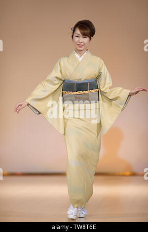 Japanische Frau, die in einem natürlichen Beige Kimono auf einer Modenschau in Kyoto, Japan. Stockfoto